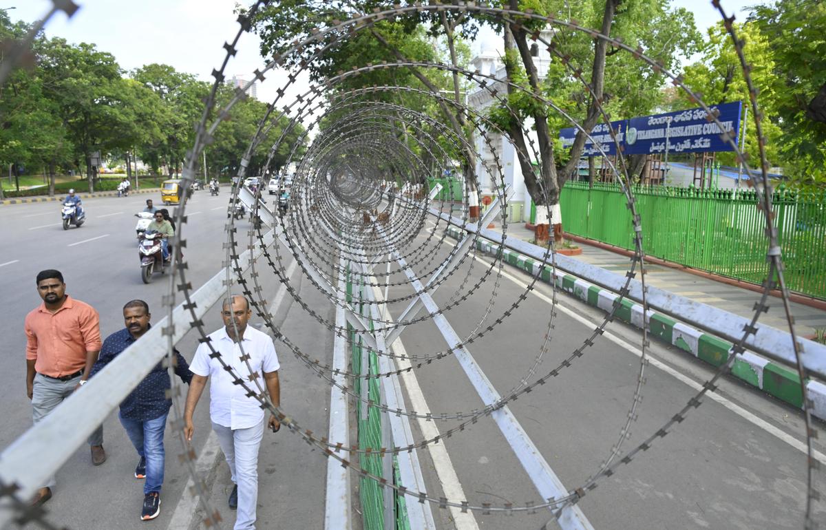 Pedestrians walk on the road in front of the State Assembly in Hyderabad on Thursday.